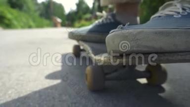 在户外的滑板公园里，特写滑板男孩骑在滑板上。 橙色滑板脚穿鞋，滑板甲板..